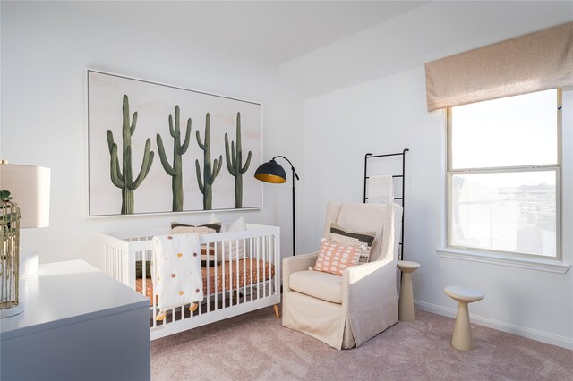 bedroom featuring a crib, baseboards, and carpet floors