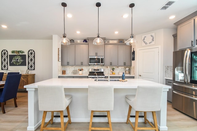 kitchen featuring a sink, visible vents, gray cabinets, and stainless steel appliances