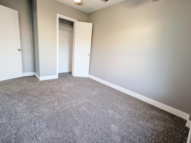 unfurnished bedroom with a closet, baseboards, and carpet flooring