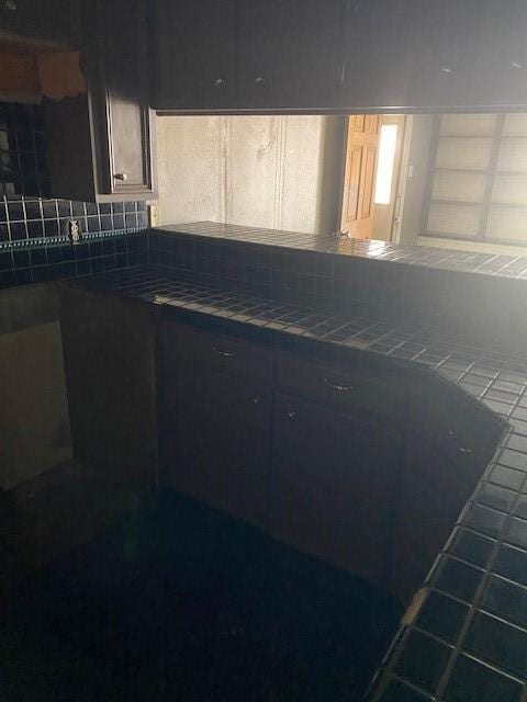 kitchen with tile patterned flooring, tile countertops, and tasteful backsplash