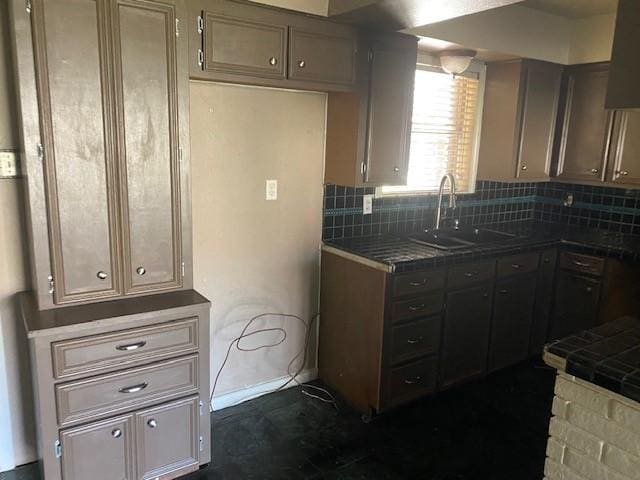 kitchen with backsplash, tile countertops, baseboards, and a sink