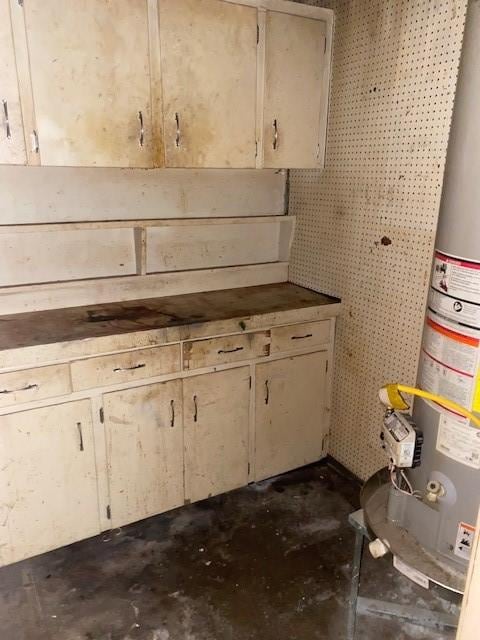 kitchen featuring gas water heater and concrete flooring