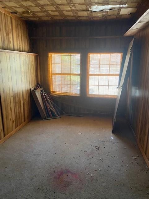 unfurnished room featuring wooden walls and an ornate ceiling