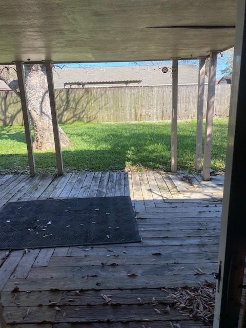 wooden terrace with a yard and fence