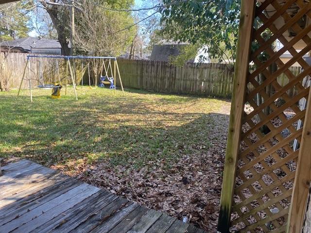 view of yard with a playground and a fenced backyard