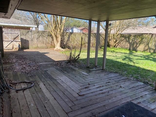 wooden deck featuring a yard and a fenced backyard