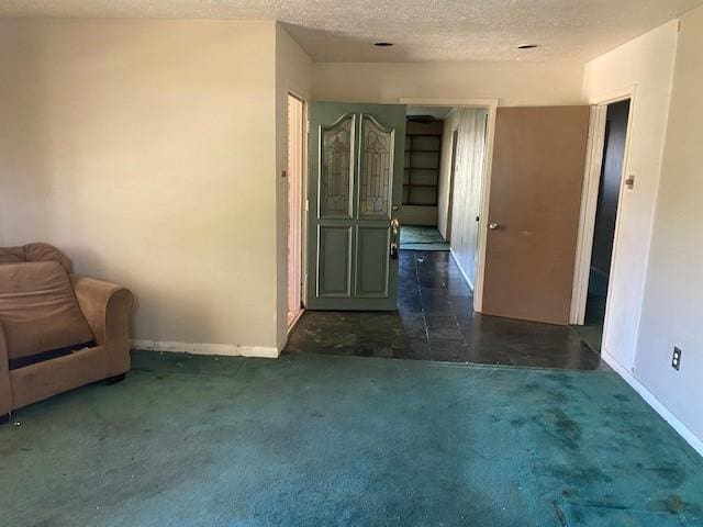 unfurnished room with baseboards, carpet floors, and a textured ceiling