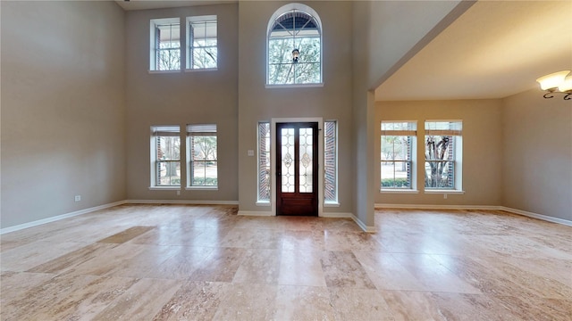 entrance foyer featuring a wealth of natural light, baseboards, and a high ceiling