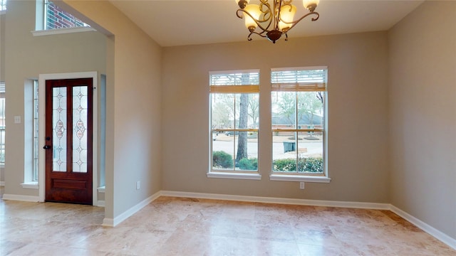 foyer with baseboards and an inviting chandelier