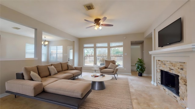 living room featuring visible vents, ceiling fan with notable chandelier, a fireplace, and baseboards