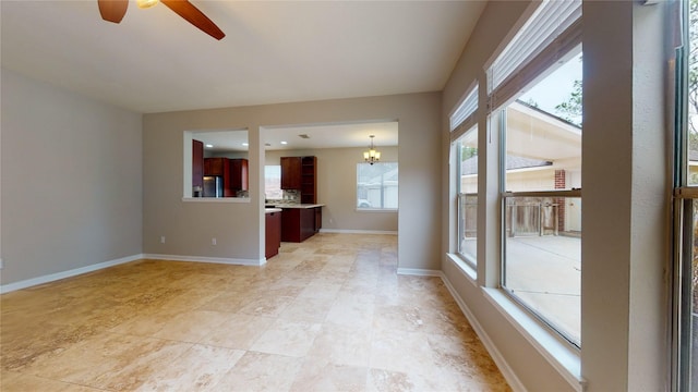 unfurnished living room with recessed lighting, baseboards, and ceiling fan with notable chandelier