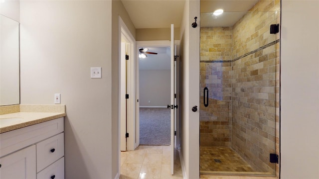 bathroom featuring baseboards, a stall shower, and vanity