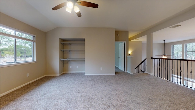 spare room featuring a wealth of natural light, visible vents, baseboards, and carpet floors