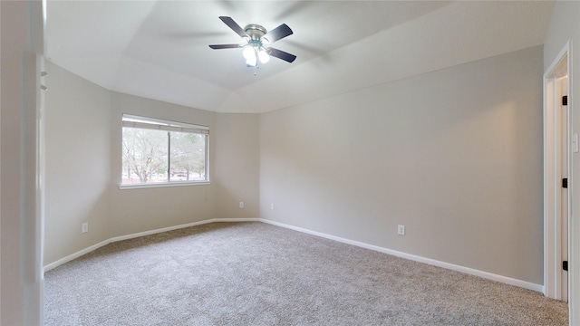 carpeted empty room featuring a ceiling fan, lofted ceiling, and baseboards