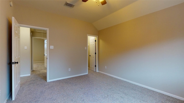 unfurnished bedroom featuring baseboards, visible vents, carpet floors, attic access, and vaulted ceiling