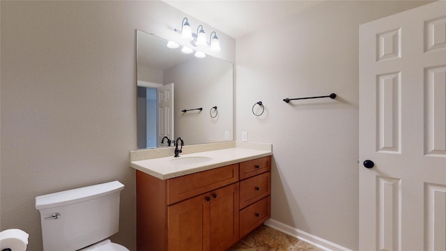 bathroom featuring toilet, vanity, and baseboards