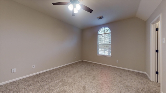 empty room featuring visible vents, a ceiling fan, baseboards, carpet, and lofted ceiling