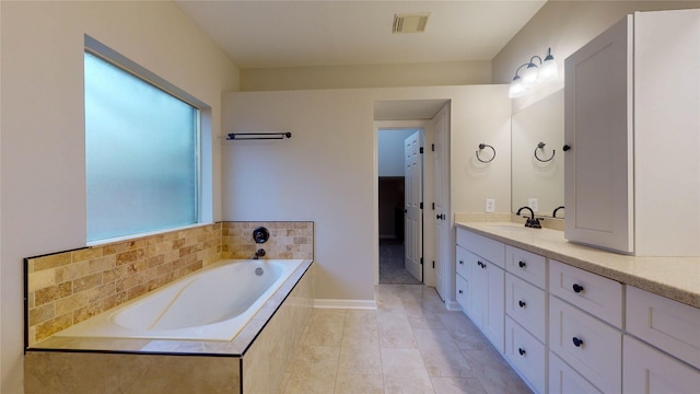 bathroom with tile patterned floors, visible vents, a garden tub, baseboards, and vanity