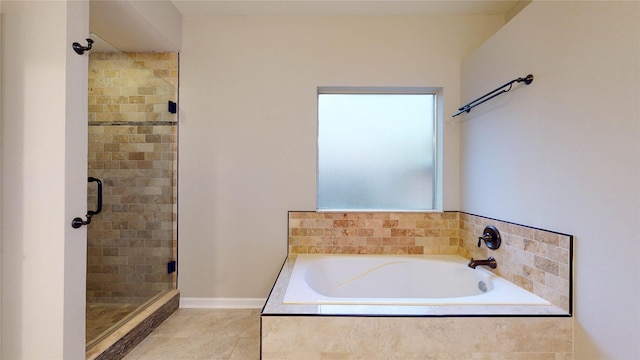 bathroom with a bath, a shower stall, and tile patterned floors