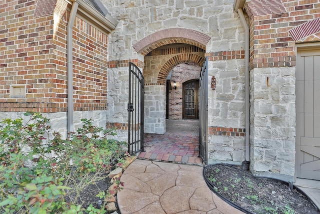 entrance to property featuring brick siding and stone siding