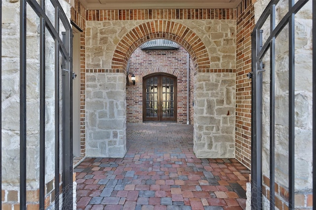 doorway to property featuring french doors and brick siding