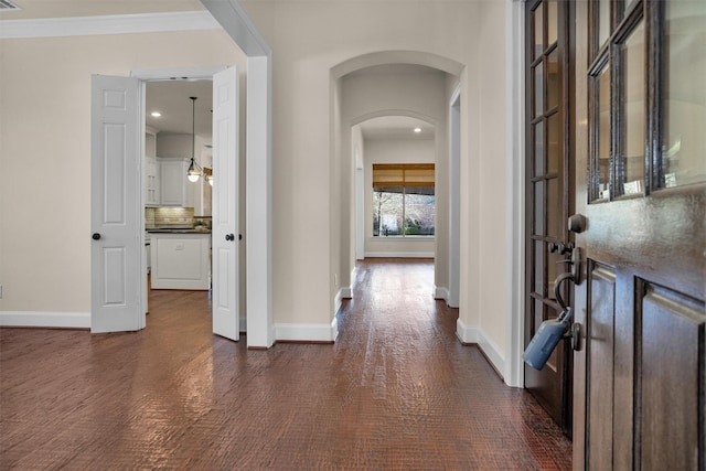 foyer entrance with recessed lighting, baseboards, arched walkways, and ornamental molding