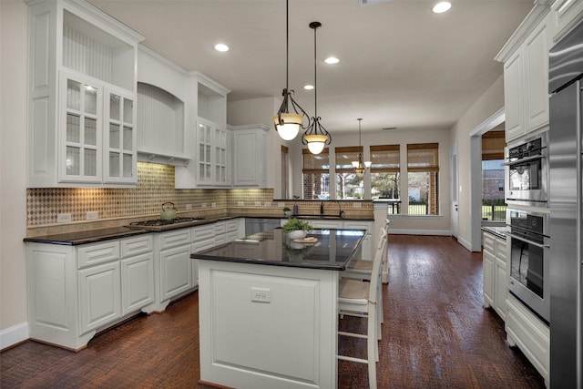 kitchen featuring tasteful backsplash, dark countertops, appliances with stainless steel finishes, and white cabinets