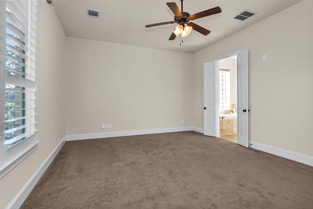 carpeted empty room with a ceiling fan, baseboards, and visible vents