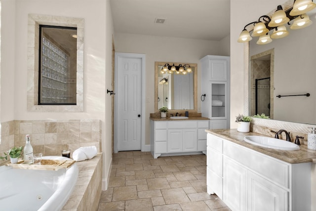 bathroom with a whirlpool tub, a stall shower, two vanities, and a sink