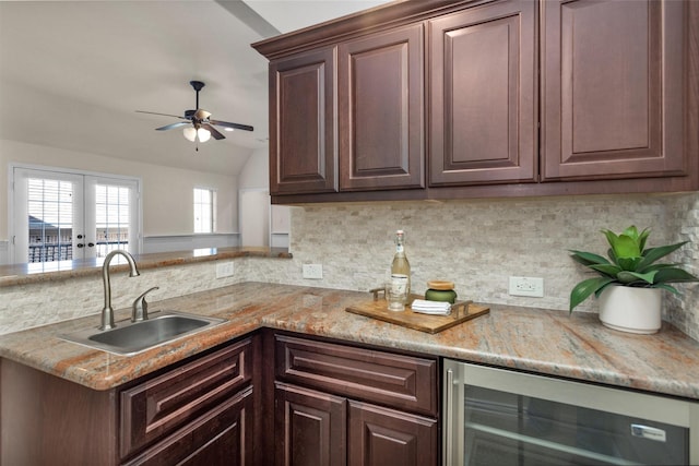 kitchen featuring beverage cooler, dark brown cabinets, backsplash, and a sink