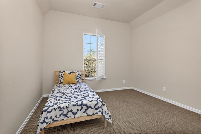 bedroom featuring visible vents, baseboards, dark carpet, and vaulted ceiling