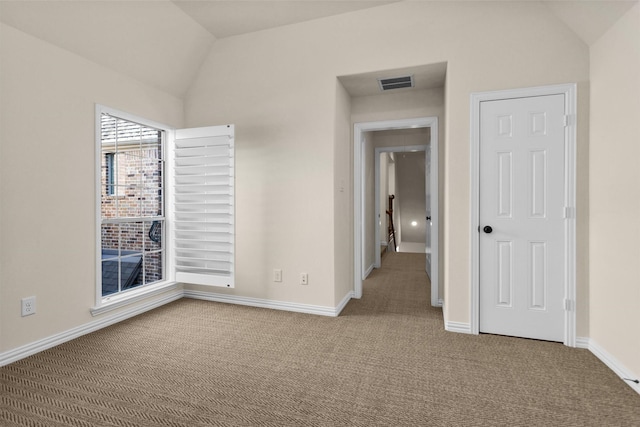 unfurnished bedroom featuring visible vents, carpet flooring, baseboards, and vaulted ceiling