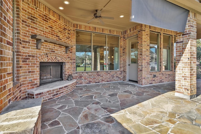 view of patio / terrace with ceiling fan and an outdoor brick fireplace