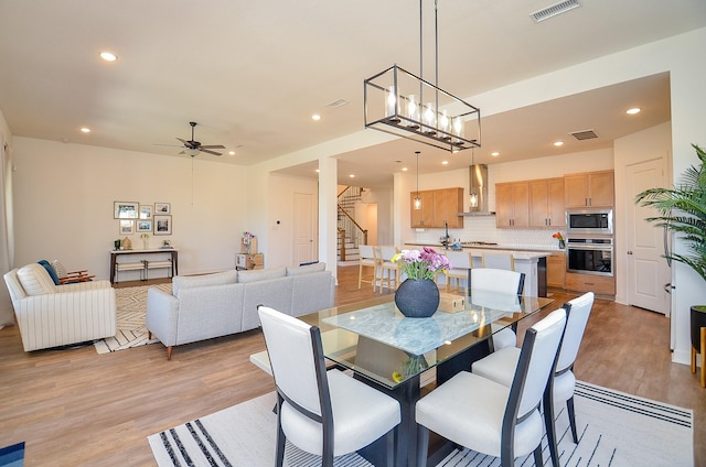 dining area featuring recessed lighting, visible vents, light wood-style flooring, and stairs