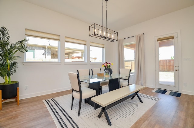 dining area with baseboards, a healthy amount of sunlight, and light wood-style flooring