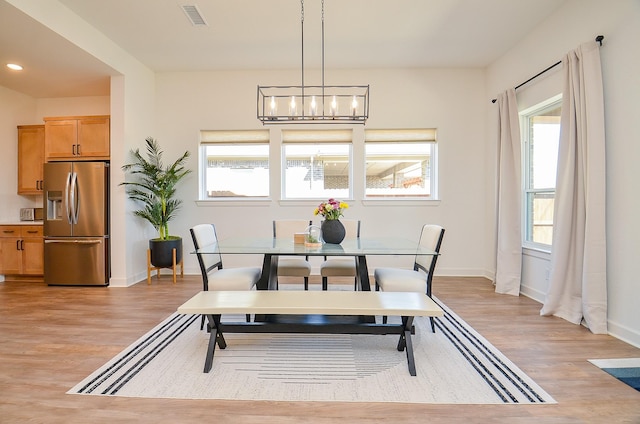 dining area with visible vents, plenty of natural light, and light wood-style floors