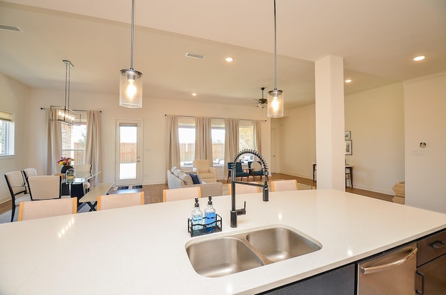 kitchen with visible vents, a healthy amount of sunlight, open floor plan, light countertops, and a sink