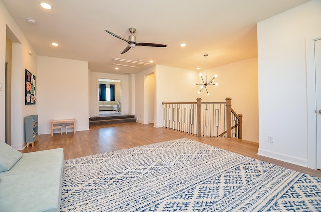 living area featuring attic access, recessed lighting, wood finished floors, and baseboards