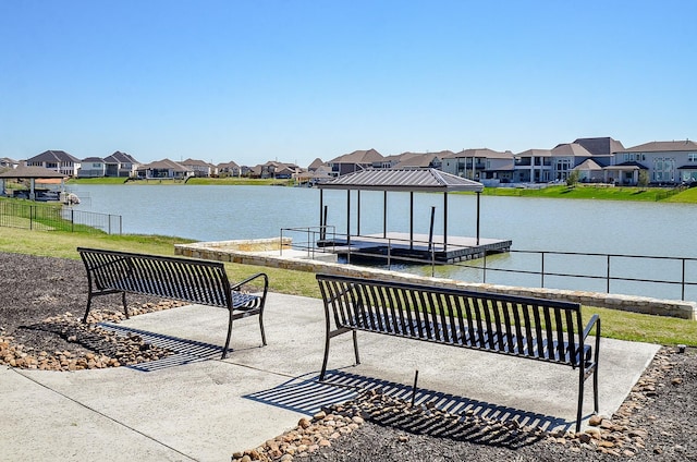 view of patio / terrace featuring a residential view, a dock, and a water view