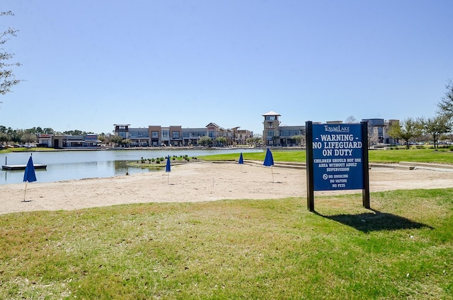 view of community featuring a yard, a water view, and volleyball court