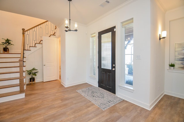 foyer featuring visible vents, stairway, light wood-type flooring, and crown molding