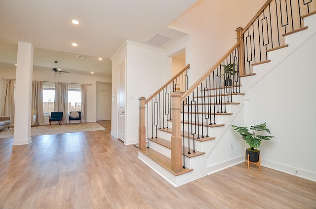 staircase with a ceiling fan, visible vents, wood finished floors, baseboards, and recessed lighting