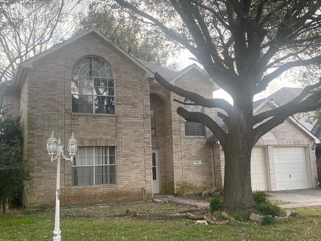 view of front of property featuring a garage, brick siding, and driveway