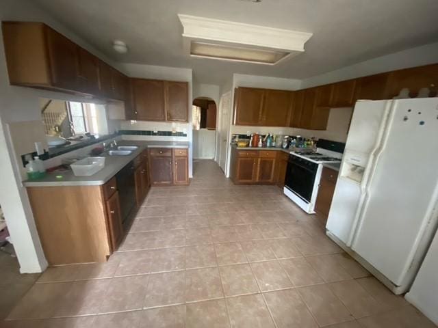 kitchen with range with electric cooktop, brown cabinetry, light tile patterned floors, white fridge with ice dispenser, and arched walkways