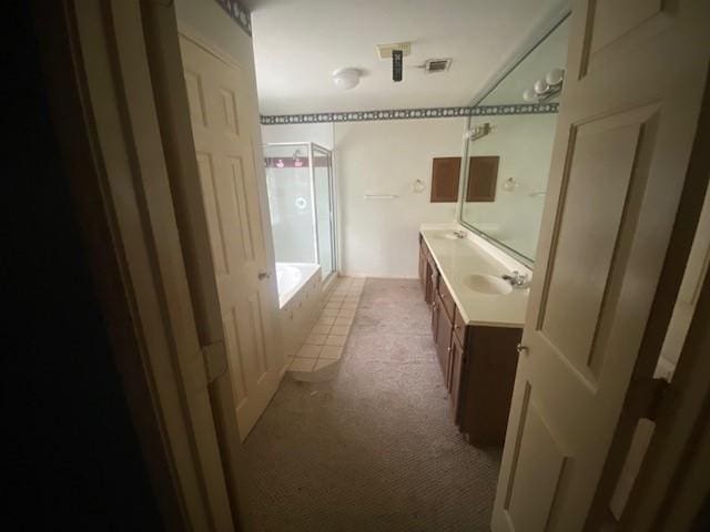 bathroom featuring visible vents, a bathtub, walk in shower, and vanity