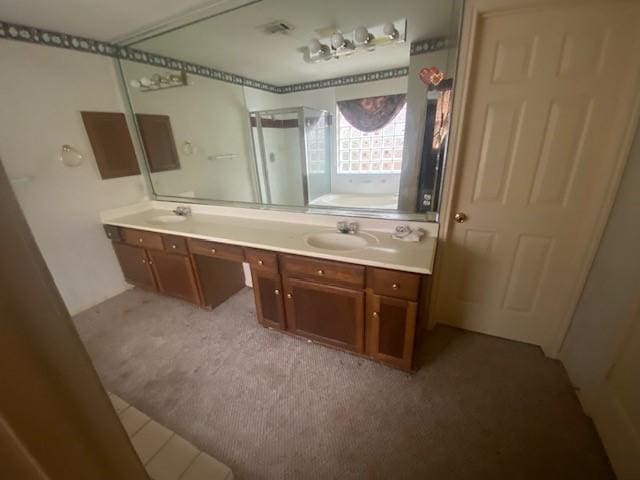 full bathroom featuring double vanity, a stall shower, a bath, and a sink