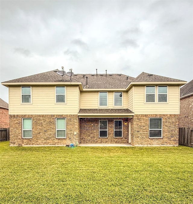 exterior space featuring a front lawn, fence, brick siding, and roof with shingles