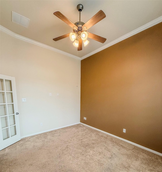 carpeted spare room with crown molding, baseboards, visible vents, and ceiling fan