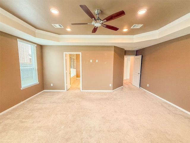 unfurnished bedroom with a tray ceiling, baseboards, and visible vents