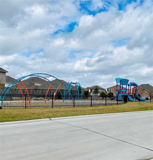 community jungle gym featuring a residential view, a yard, and fence